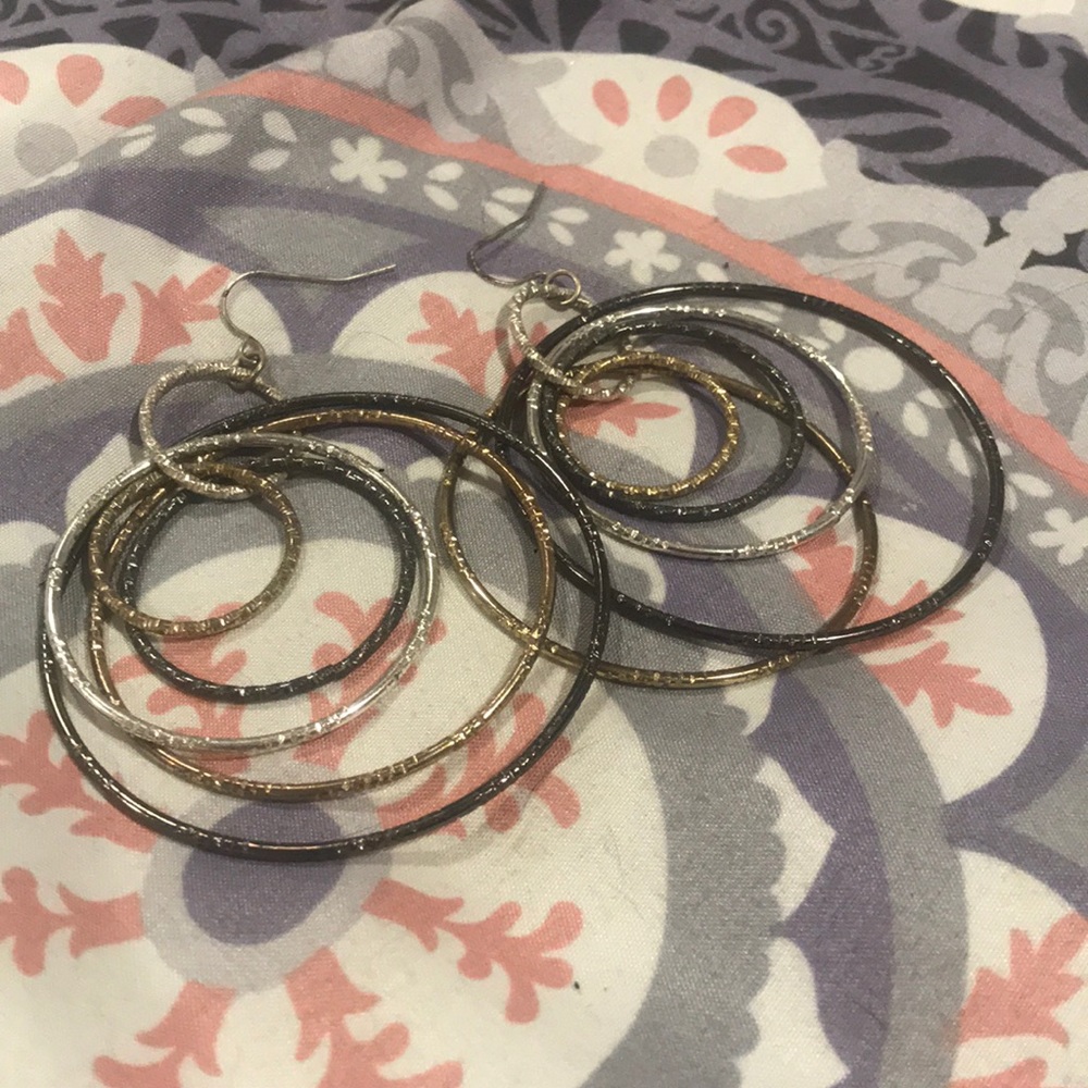 Dangly gold, silver, and black colored earrings